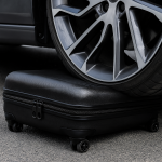 Крупным планом колесо машины на чемодане