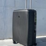 Чемодан Bizon Н01 черный, вид спереди под углом (три четверти) с поднятой выдвижной ручкой