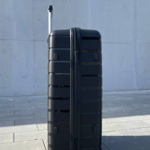 Чемодан Bizon H03 черный, вид слева с поднятой выдвижной ручкой и боковыми ножками