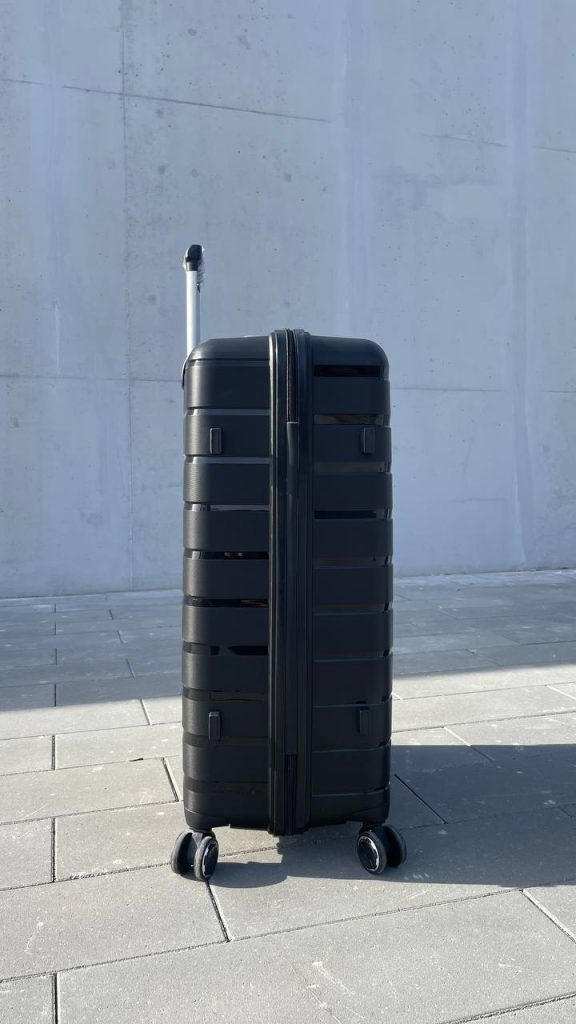 Чемодан Bizon H03 черный, вид слева с поднятой выдвижной ручкой и боковыми ножками