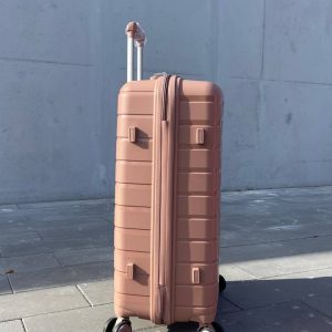 Чемодан Bizon H03 пудровый, вид слева с поднятой выдвижной ручкой и боковыми ножками