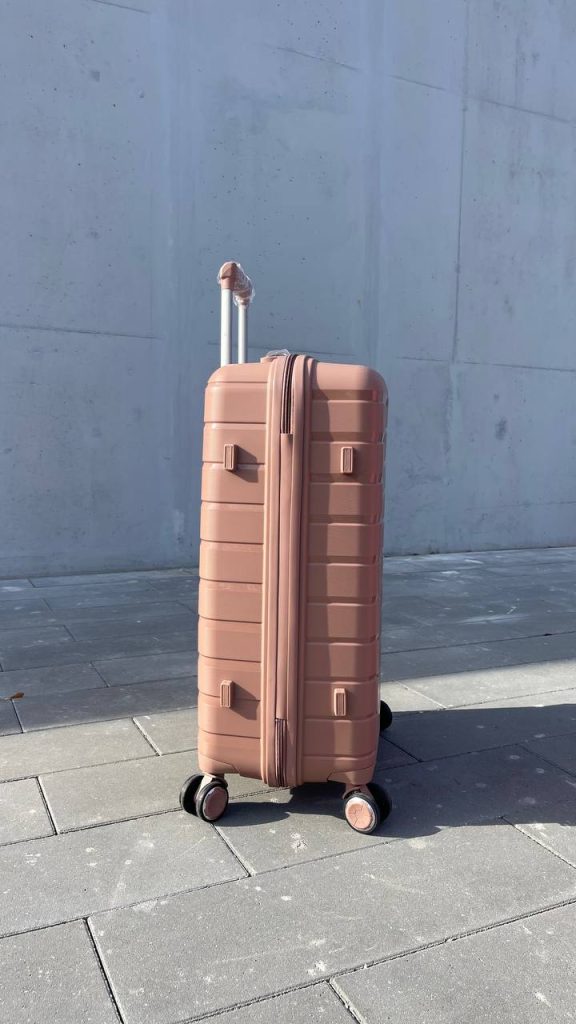 Чемодан Bizon H03 пудровый, вид слева с поднятой выдвижной ручкой и боковыми ножками