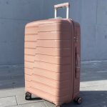 Чемодан Bizon Н03 пудровый, вид спереди под углом (три четверти) с поднятой выдвижной ручкой