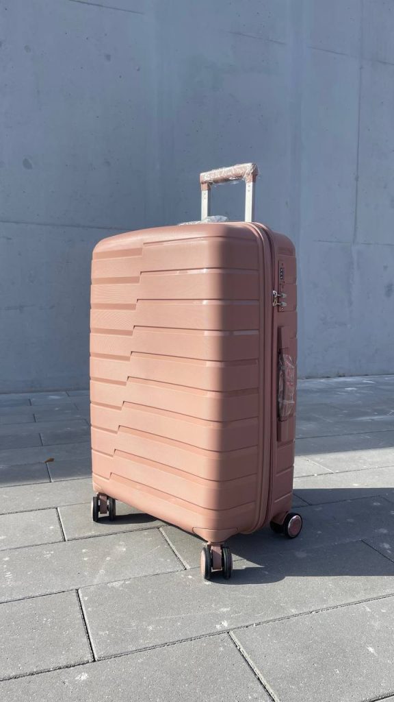 Чемодан Bizon Н03 пудровый, вид спереди под углом (три четверти) с поднятой выдвижной ручкой