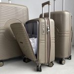 Чемодан Mybag Krug бежевый, вид под углом три четверти спереди с поднятой выдвижной ручкой, открытым дополнительным отделением рядом с чемоданами бежевого цвета с поднятыми ручками