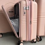 Чемодан Mybag Krug персиковый, вид под углом три четверти спереди крупным планом с поднятой выдвижной ручкой, открытым дополнительным отделением рядом с чемоданами персикового цвета