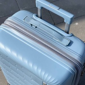 Чемодан Freedom NW голубой, вид с верху с поднятой телескопической ручкой, показа на молния и ручка для переноски
