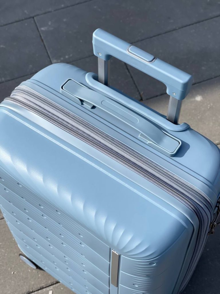 Чемодан Freedom NW голубой, вид с верху с поднятой телескопической ручкой, показа на молния и ручка для переноски