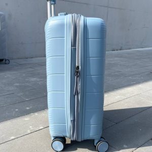 Чемодан Freedom NW голубой, вид слева с поднятой выдвижной ручкой и боковыми ножками