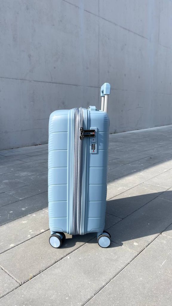 Чемодан Freedom NW голубой, вид справа с поднятой выдвижной ручкой, показаны молния, боковая ручка и кодовый замок