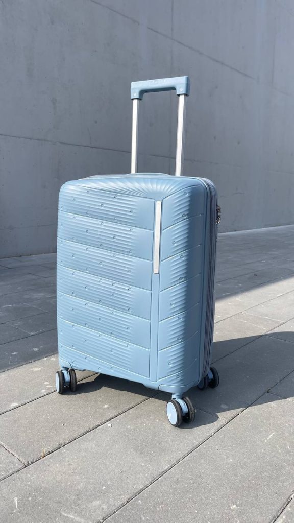 Чемодан Freedom NW голубой, вид спереди под углом (три четверти) с поднятой выдвижной ручкой