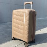 Чемодан Freedom NW бежевый, вид спереди под углом (три четверти) с поднятой выдвижной ручкой