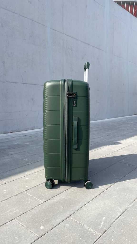 Чемодан Freedom NW зелёный, вид справа с поднятой выдвижной ручкой, показаны молния, боковая ручка и кодовый замок