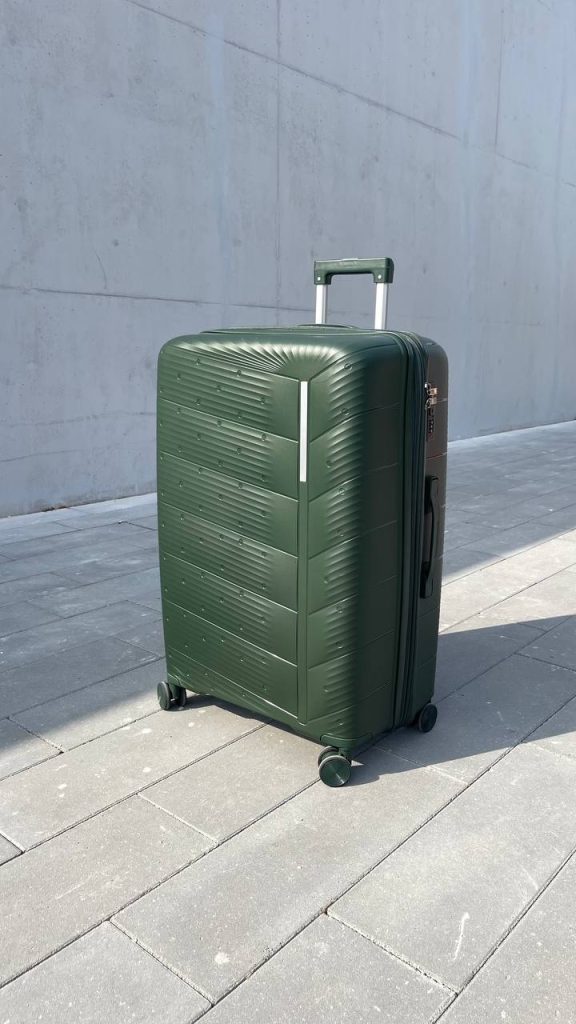 Чемодан Freedom NW зелёный, вид спереди под углом (три четверти) с поднятой выдвижной ручкой