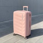 Чемодан Freedom NW персиковый, вид с переди с поднятой выдвижной ручкой