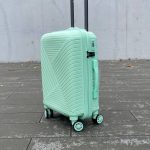 Чемодан Bizon H07 мятный, вид спереди под углом (три четверти) с поднятой выдвижной ручкой