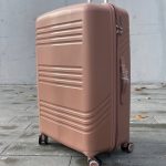 Чемодан Bizon H08 пудровый, вид спереди под углом (три четверти) с поднятой выдвижной ручкой