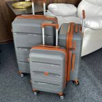 3 Чемодана Mironpan Paradise серые, размера S M L стоящие рядом с поднятыми ручками под углом три четверти сверху